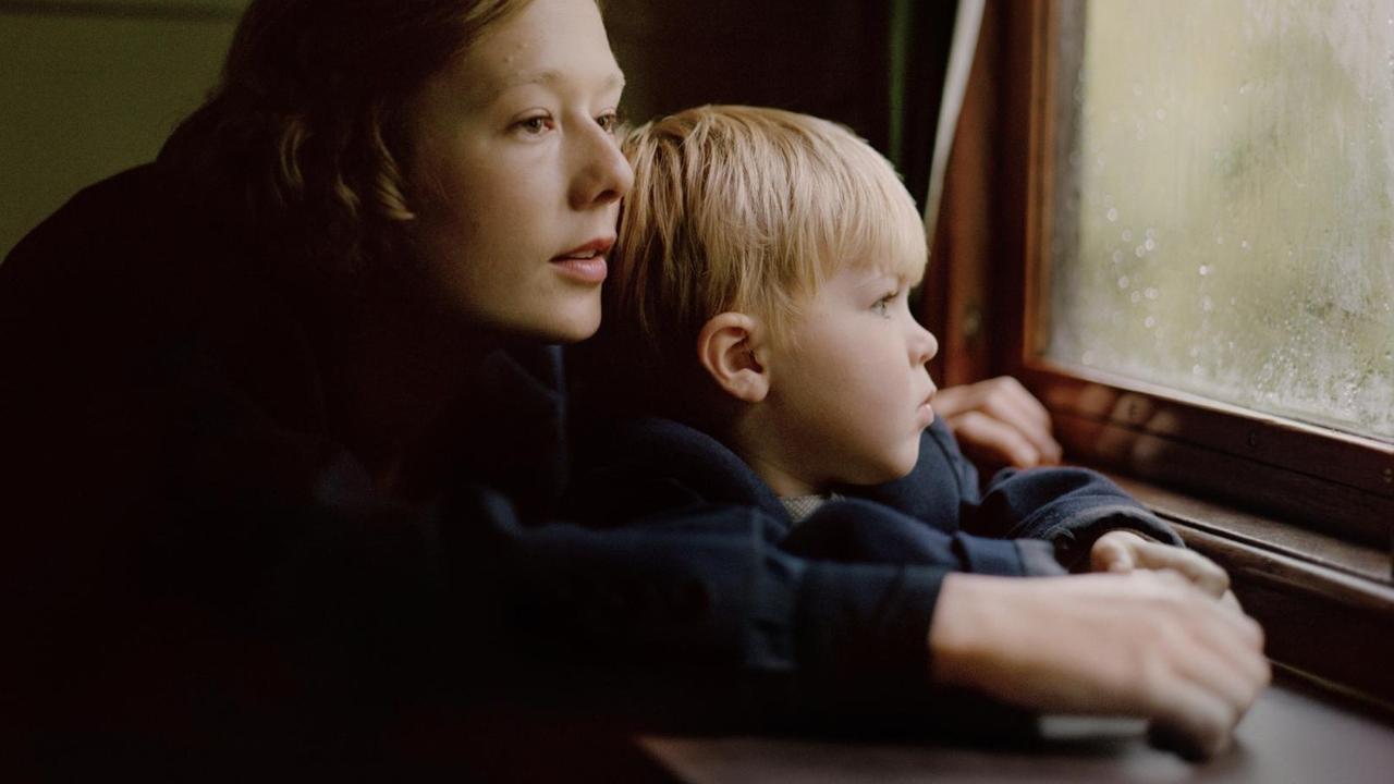 Die junge Astrid Lindgren hält ihren Sohn im Arm und blickt aus einem Fenster.