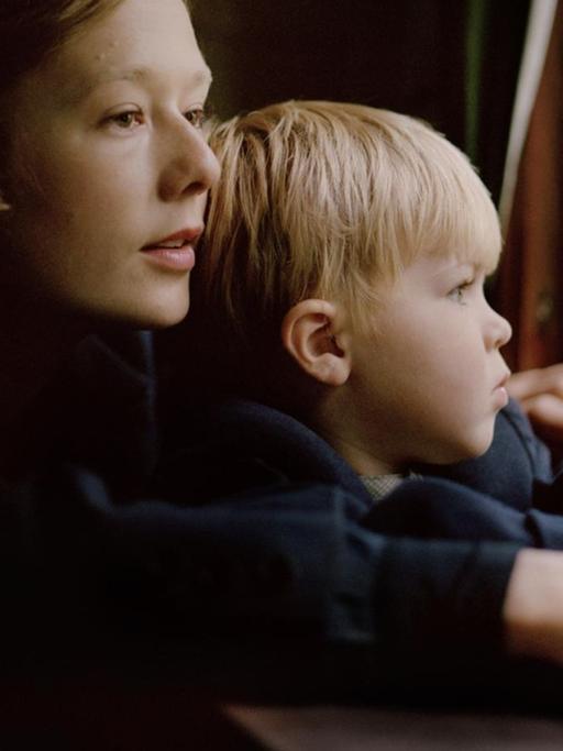 Die junge Astrid Lindgren hält ihren Sohn im Arm und blickt aus einem Fenster.