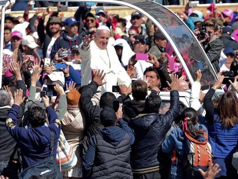 Papst Franziskus wird bei seiner Fahrt durch die Straßen von Mexiko-Stadt von tausenden Menschen umringt und bejubelt.