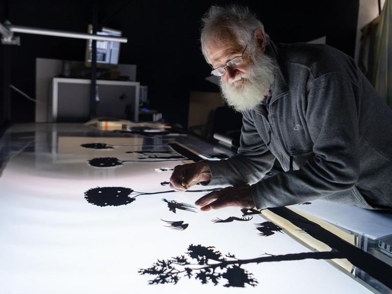 Jörg Herrmann, Silhouettenfilm-Macher, arbeitet in seiner Werkstatt an einer Filmszene. Trotz der modernen Technik pflegt der 77-Jährige die alte Kunst der manuellen Silhouettenanimation. Er ist einer der letzten aktiven Silhouettenfilmer weltweit.
