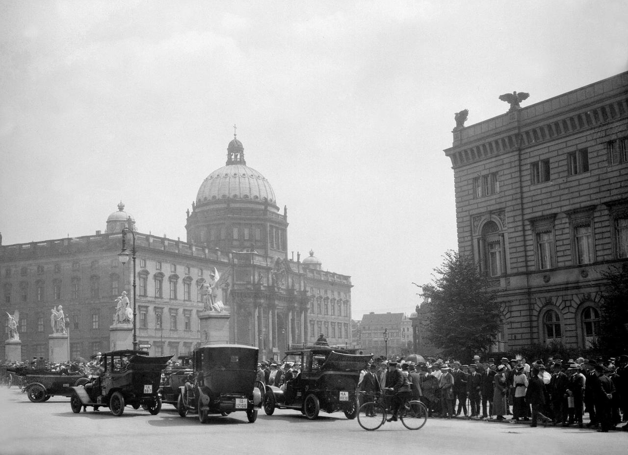 Blick auf Berlin-Mitte um 1920. Vorne ein breiter Platz mit Automobilen, im Hintergrund der Berliner Dom.