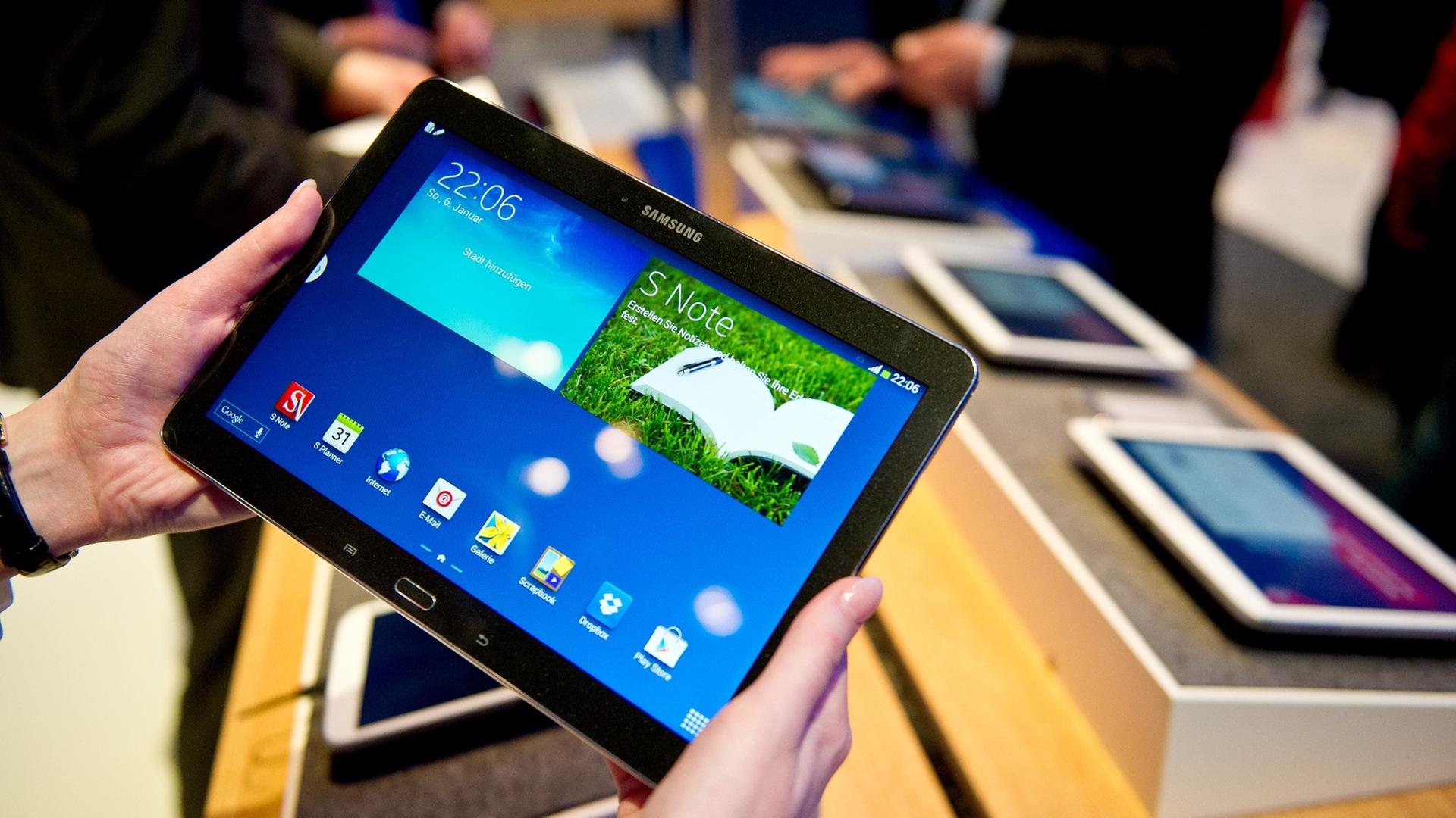 Eine Frau hält am 11.03.2014 am Vodafonestand auf der Computermesse CeBIT in Hannover (Niedersachsen) ein Samsung-Tablet mit dem Namen "Samsung GALAXY Note 10.1 LTE 2014". Das Tablet ist eine Neuheit von Samsung. Foto: Christoph Schmidt/dpa Eine Frau hält am 11.03.2014 am Vodafonestand auf der Computermesse CeBIT in Hannover (Niedersachsen) ein Samsung-Tablet mit dem Namen "Samsung GALAXY Note 10.1 LTE 2014". Das Tablet ist eine Neuheit von Samsung. Foto: Christoph Schmidt/dpa