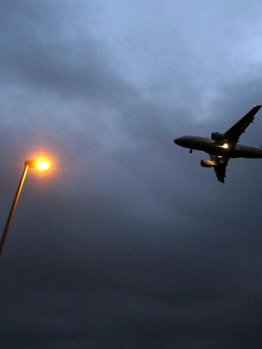 Ein Flugzeug der Lufthansa landet am 20.10.2014 am Flughafen in Frankfurt am Main (Hessen). Im Vordergrund ist eine Laterne zu sehen.
