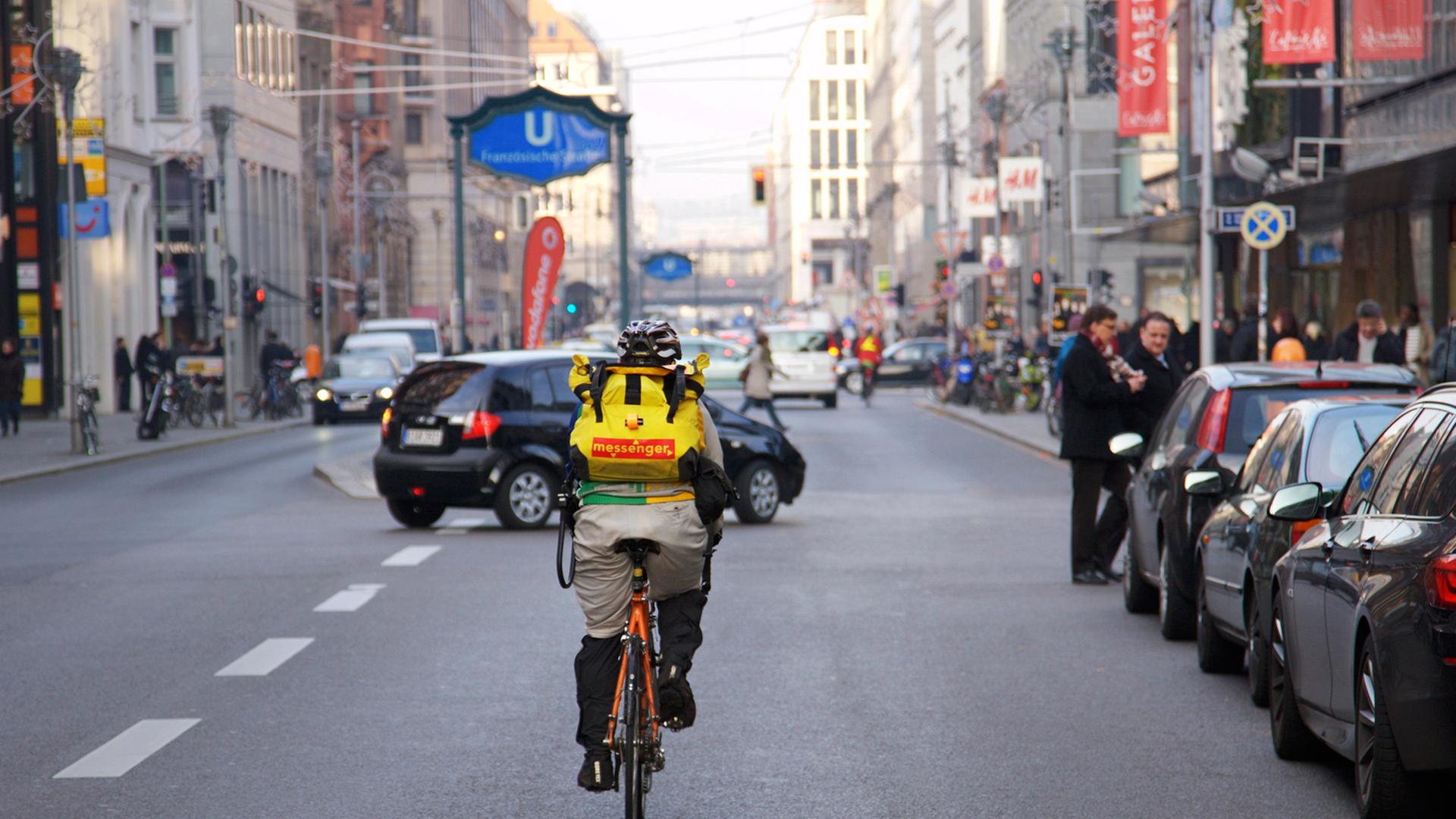 Ein Fahrradkurier fährt in Berlin auf der Friedrichstraße im Bezirk Mitte