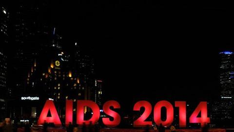 Viele Menschen versammeln sich vor dem Schriftzug "Aids 2014" in Melbourne, der für die 20. Internationale Aids-Konferenz aufgestellt wurde. Dabei wurde auch der Opfer des in der Ukraine abgestürzten Flugzeugs gedacht. An Bord waren bis zu hundert Menschen, die auf dem Weg zur Aids-Konferenz waren.