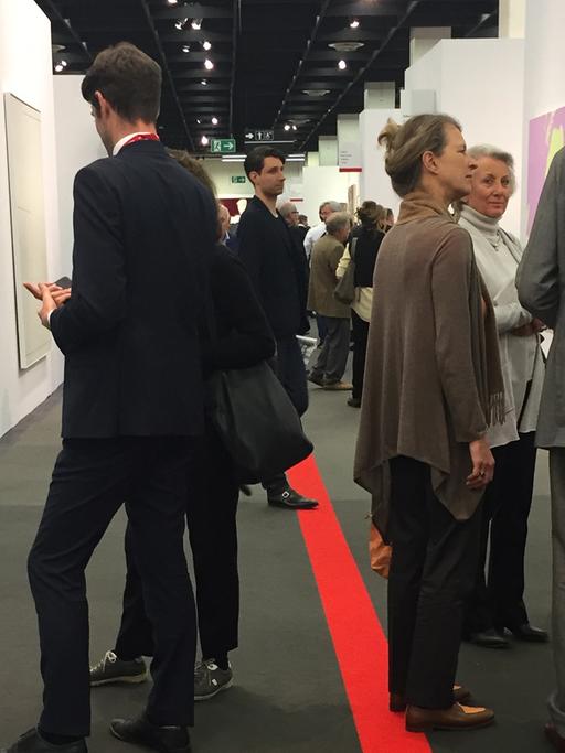 Auf der Art Cologne diskutieren Besucher und Galeristen über Kunstwerke und ihre Preise.