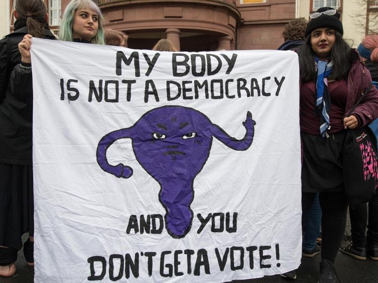Mit einem Plakat sprechen sich Demonstrantinnen am 24.11.2017 vor dem Amtsgericht in Gießen (Hessen) für die Selbstbestimmung von Frauen beim Thema Abtreibung aus. Auf ihrem Plakat steht "My body is not a democracy - and you don't get a vote" ("Mein Körper ist keine Demokratie - und Du bekommst keine Stimme"). Im Gericht muss sich die Ärztin Kristina Hänel verantworten. Sie soll auf ihrer Homepage für Abtreibung geworben haben und sich damit strafbar haben.
