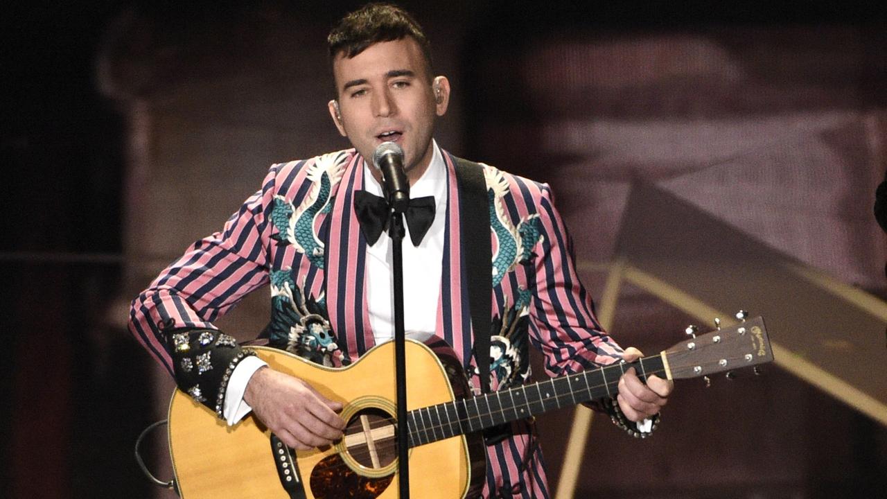 Der US-Musiker Sufjan Stevens steht mit einer Gitarre am 4. März 2018 bei der Oscar-Verleihung auf der Bühne und singt "Mystery of Love" aus dem Film "Call Me By Your Name" in ein Mikrofon. Der US-Musiker Sufjan Stevens steht mit einer Gitarre am 4. März 2018 bei der Oscar-Verleihung auf der Bühne und singt "Mystery of Love" aus dem Film "Call Me By Your Name" in ein Mikrofon.