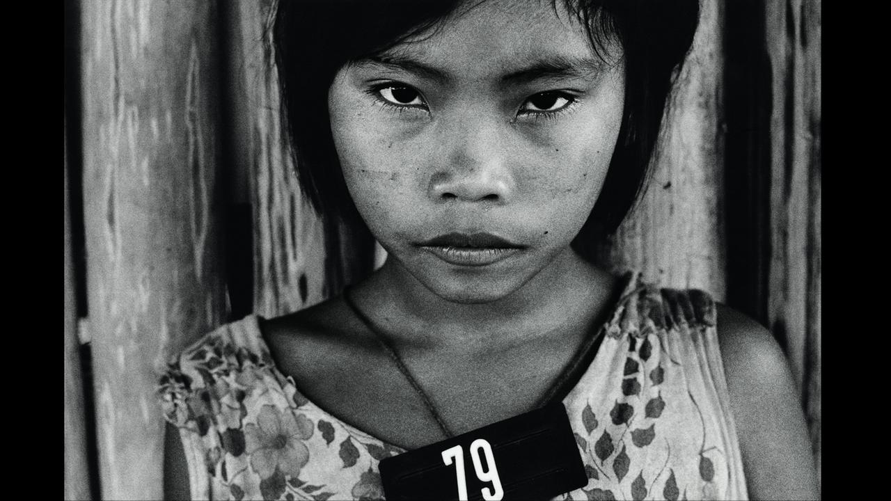 Fotografie von Claudia Andujar eines Mädchens aus dem Volk der Yanomami in Brasilien. Um den Hals des Mädchens hängt eine Kette mit der Nummer 79.