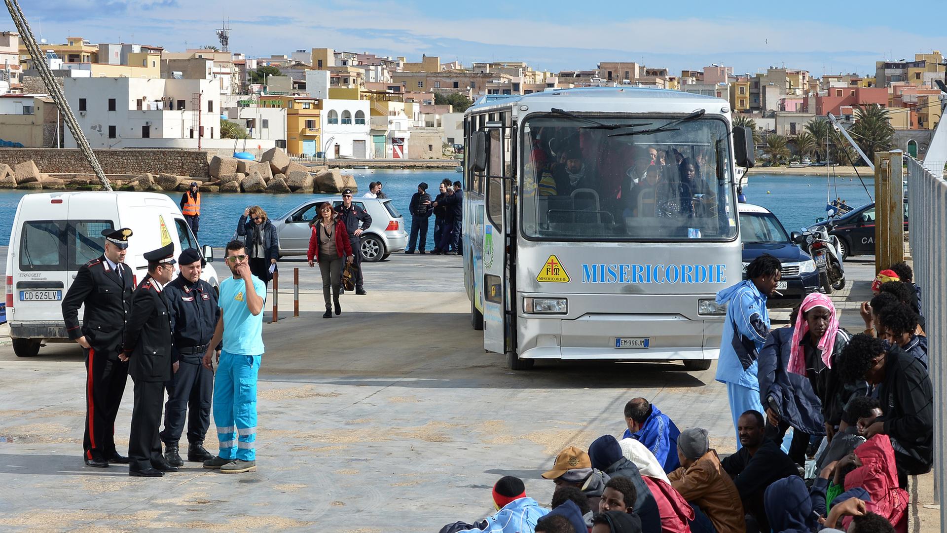 Flüchtlinge auf der Insel Lampedusa warten darauf, mit einer Fähre nach Sizilien gebracht zu werden.