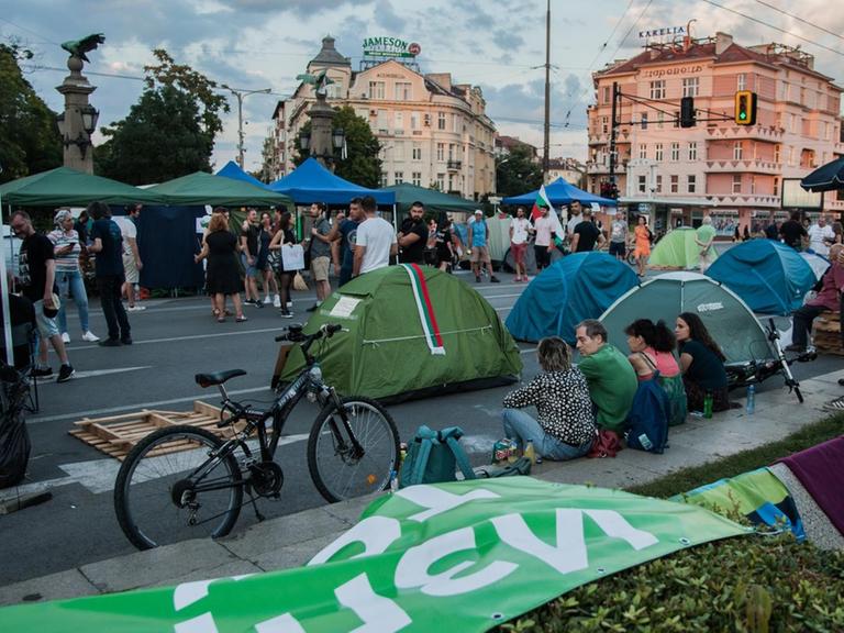 Demonstranten sitzen am Straßenrand und blockieren mit aufgeschlagenen Zelten die Straßen.