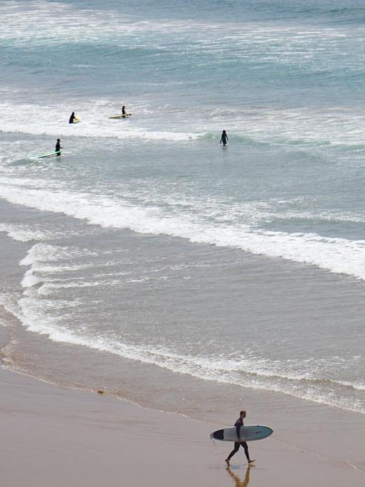 Touristen surfen und baden am 29.03.2016 in Taghazout (Marokko) am Strand an der Atlantikküste.
