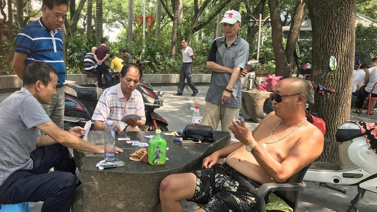 Fünf Männer sitzen in einem Park in der südchinesischen Stadt Fuzhou, spielen Karten und sprechen über Politik