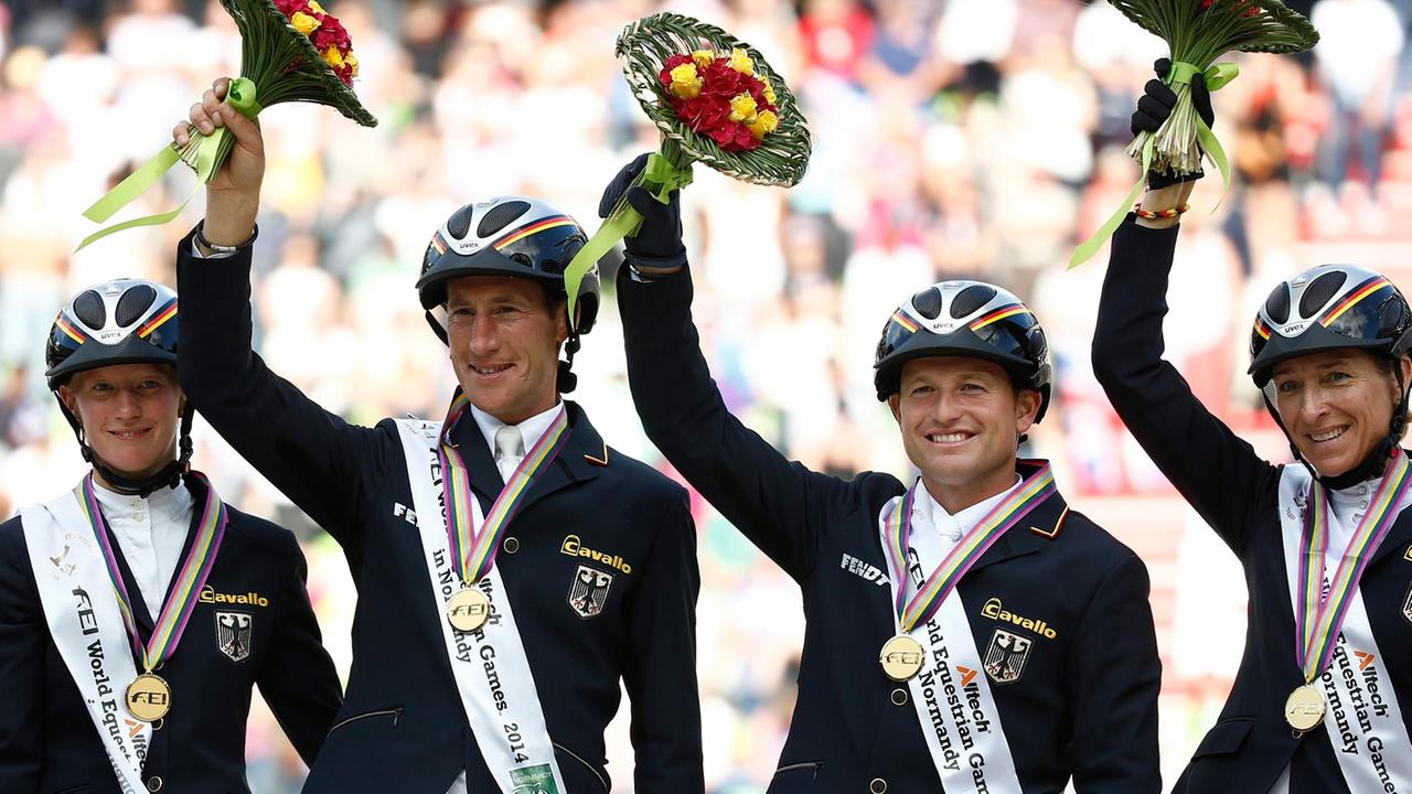 Die deutschen Vielseitigkeitsreiter Sandra Auffarth, Dirk Schrade, Michael Jung und Ingrid Klimke (von links) freuen sich über ihre Goldmedaille. Die deutschen Vielseitigkeitsreiter Sandra Auffarth, Dirk Schrade, Michael Jung und Ingrid Klimke (von links) freuen sich über ihre Goldmedaille.