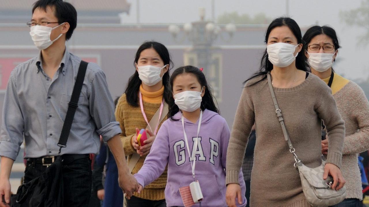 Chinesische Familie lauft mit Atemschutz durch China ( 27.03.2014)