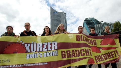 Studenten laufen mit einem Transparent mit der Aufschrift "Kürzer geht's nicht! Bildung braucht Zukunft!" am 25.06.2014 zu einer Kundgebung auf dem Augustusplatz in Leipzig (Sachsen).