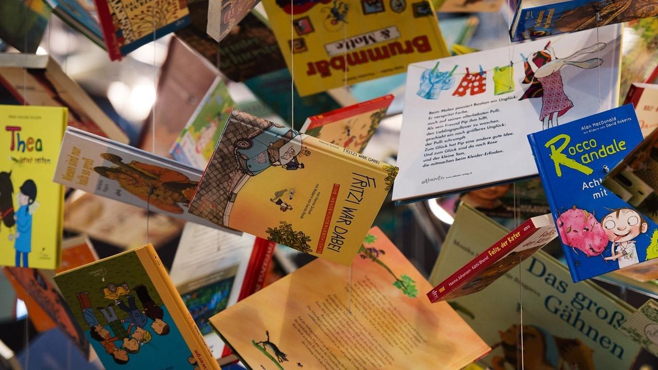 An der Decke über dem Stand der Kooperation Kinder- und Jugendbuch des Deutschen Taschenbuch Verlages (dtv) hängen am 14.03.2014 auf der Leipziger Buchmesse in Leipzig (Sachsen) Bücher an Fäden.