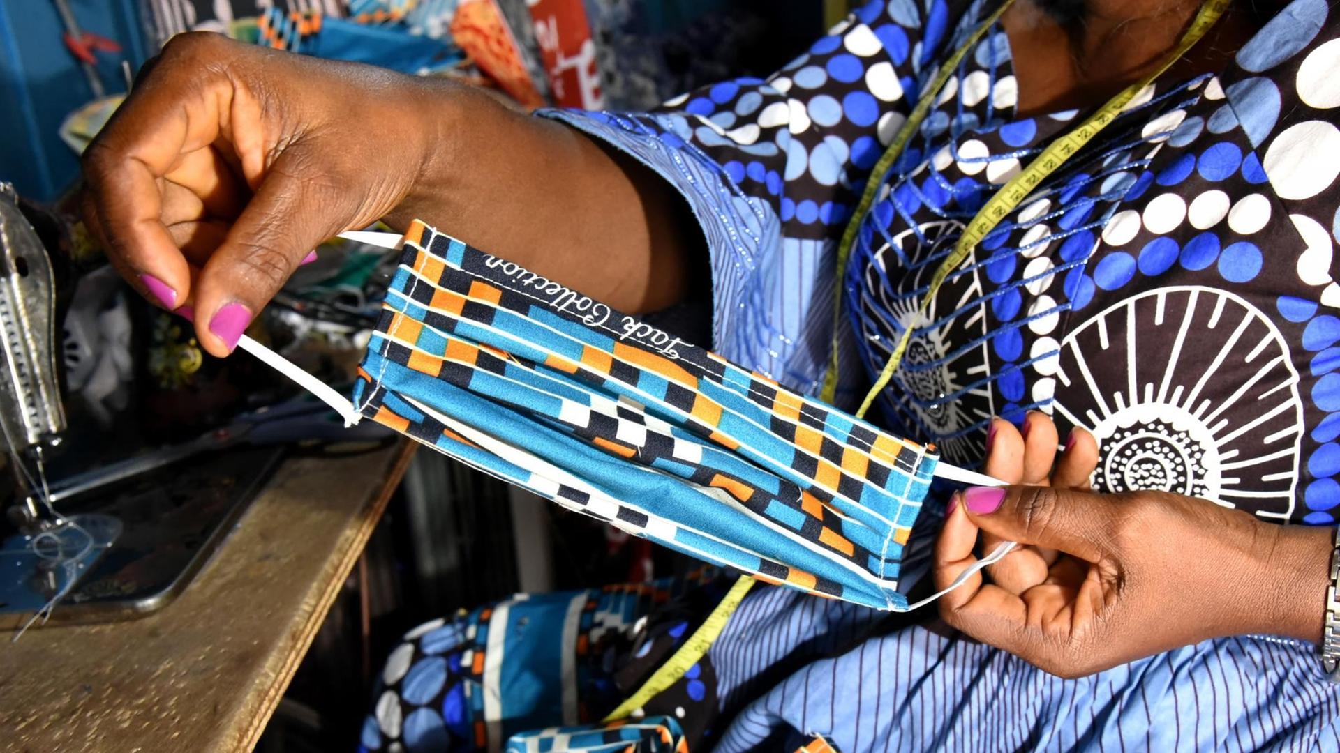 Angeline Toungsi, eine kamerunische Schneiderin, näht in ihrer Werkstatt in Yaounde Stoffgesichtsmasken.