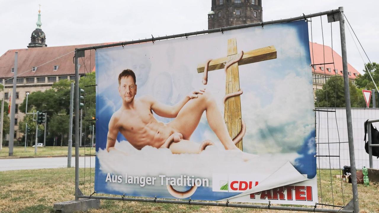 Auf einem Plakat von "Die Partei" auf dem Georgsplatz in Dresden ist der Sächsische CDU Ministerpräsident Michael Kretschmer abgebildet.