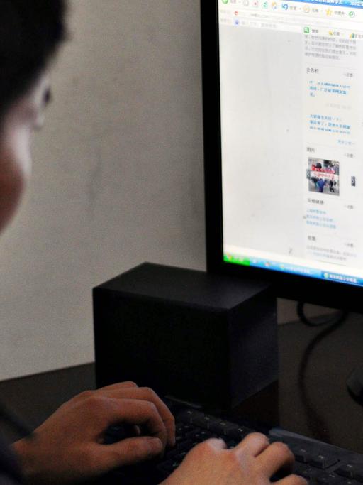 Ein Chinese sitzt vor einem Computer und nutzt den Twitter-ähnlichen Mikroblogdienst Weibo.