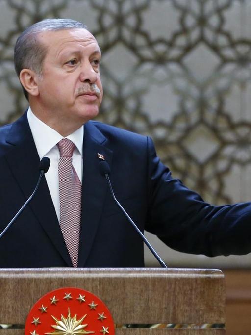 Der türkische Präsident Recep Tayyip Erdogan hält eine Rede, hinter ihm sind zwei türkische Flaggen zu sehen.