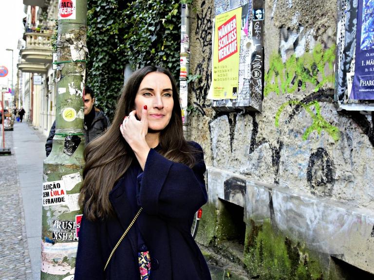 Mirna Funk steht auf einer Straße in Berlin.