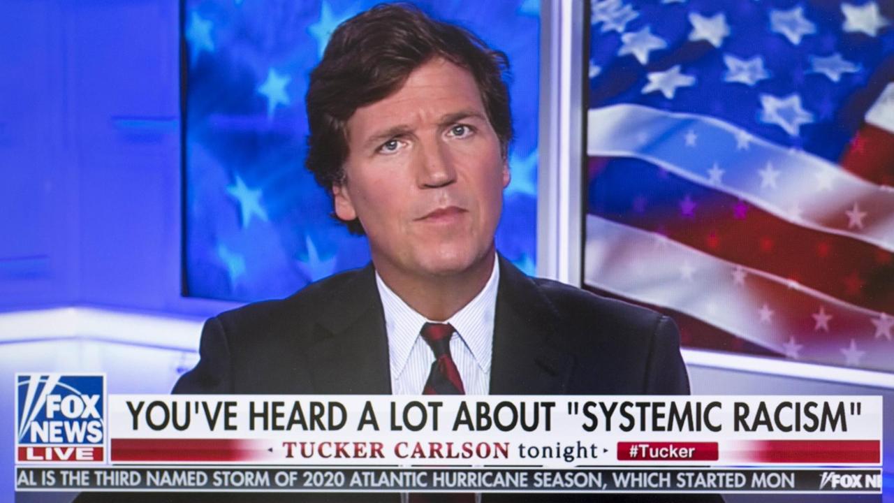 Tucker Carlson in seiner TV-Show, in einem Spruchband steht "Sie haben viel über 'systematischen Rassismus' gehört."