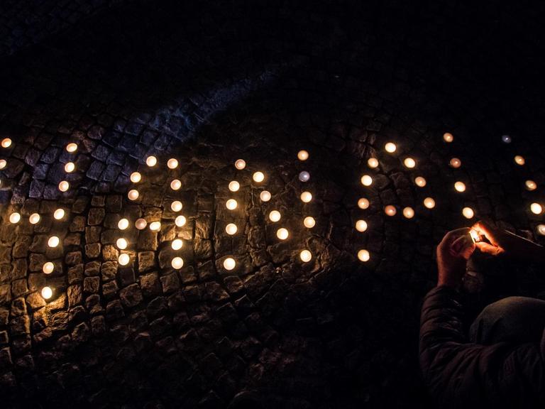 In München haben Menschen bei einer Gedenkveranstaltung mit Kerzen das Wort "Hanau" gebildet