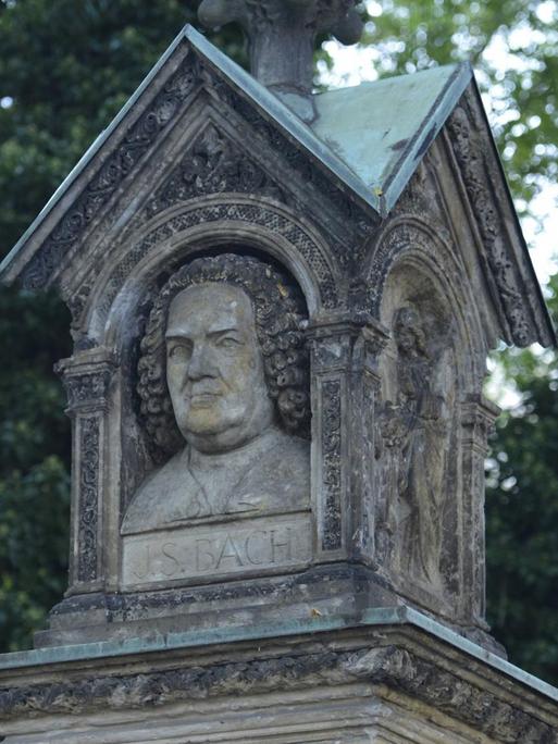 Eine Säule zeigt Bachs Porträt, das von einem Dach geschützt ist.