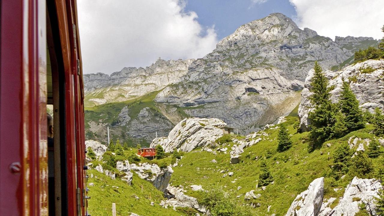 Ein Blick aus einem fahrenden Schweizer Zug auf die Berge bei Luzern