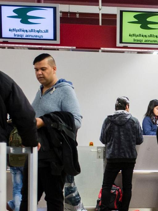 Reisende und Flüchtlinge an Check-In-Schaltern in Berlin-Tegel eines Fluges der Iraqi Airways nach Erbil,