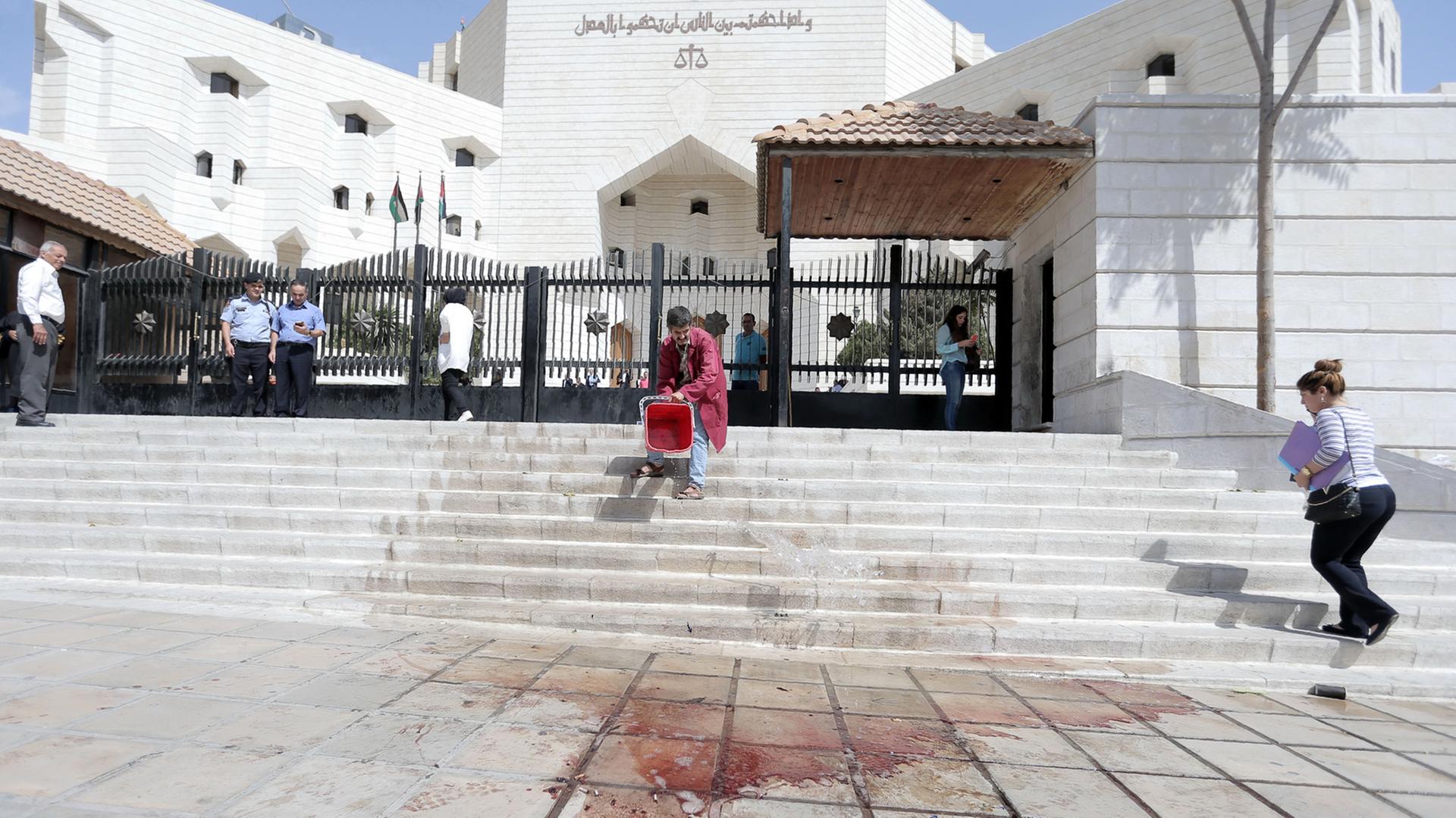 Ein Mann reinigt die Treppe vor dem Gerichtsgebäude in Amman. Hier war der jordanische Journalist und Autor Nahed Hattar von einem unbekannten Täter erschossen worden.