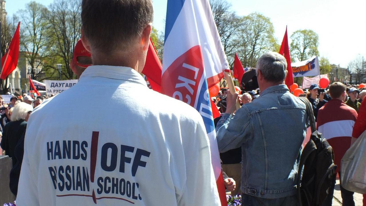 Bei einer Demonstration in Riga trägt ein Mann ein Tshirt mit der Aufschrift "Hands off Russian schools", um damit gegen die Reduzierung des Schulunterrichts auf Russisch in Lettland zu demonstrieren