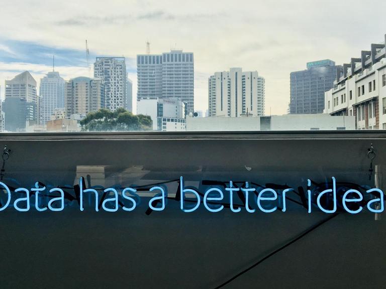 Der Schriftzug "Data has a better idea" leuchtet unter eínem Fenster an der Wand.