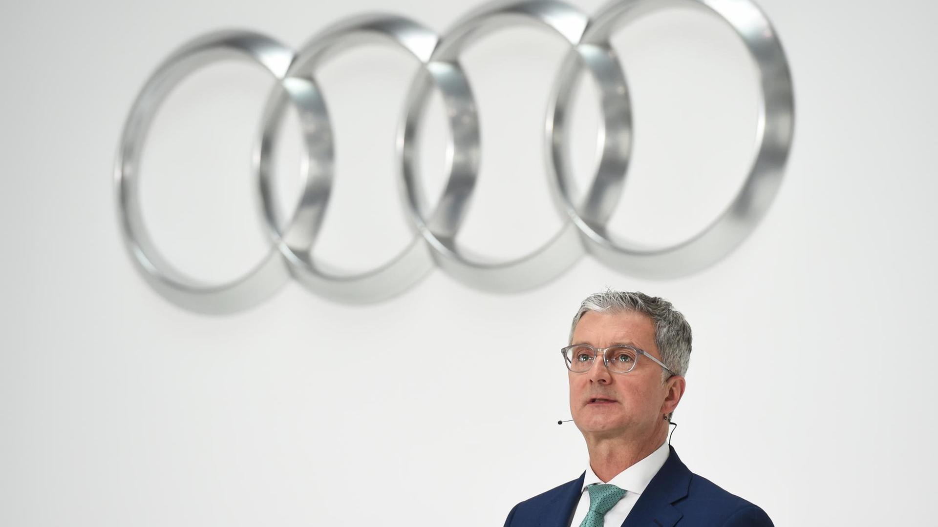 Rupert Stadler steht unter dem Audi-Logo aus vier Ringen