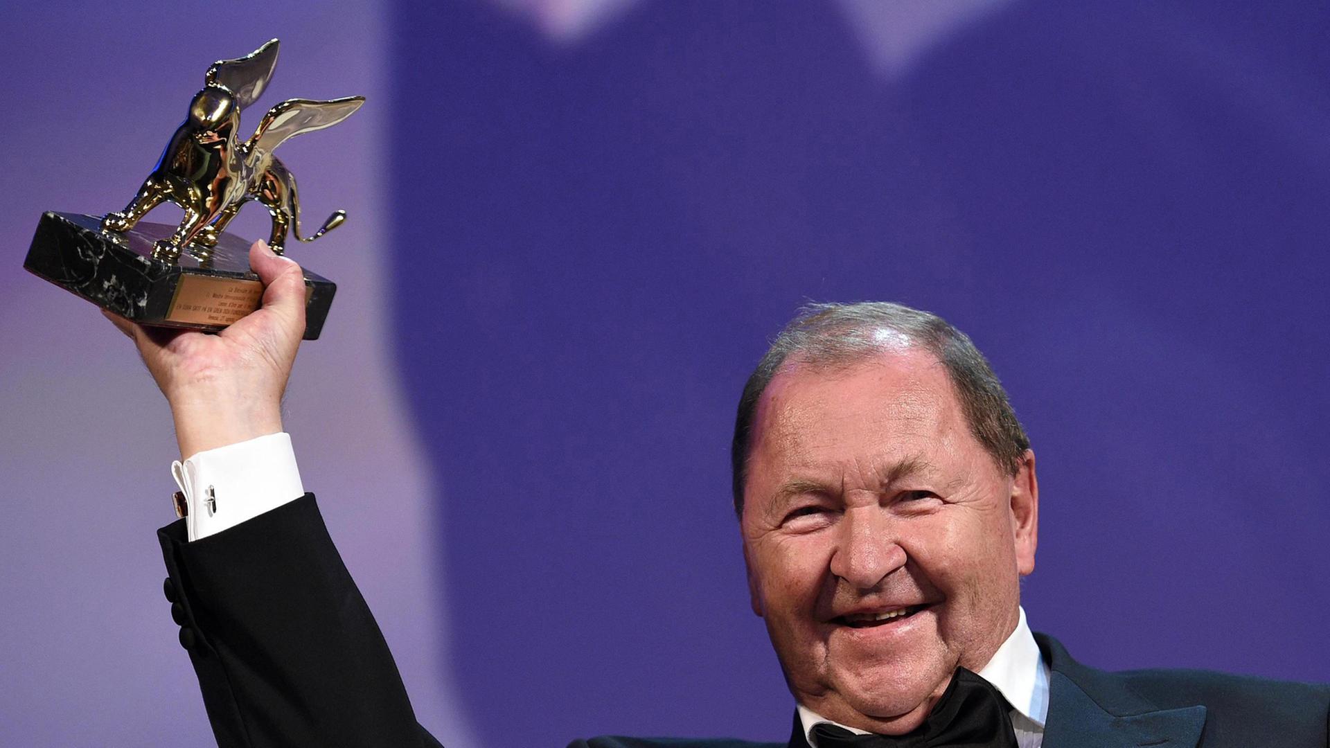 Der Schwede Roy Andersson recht den Goldenen Löwen in die Höhe.