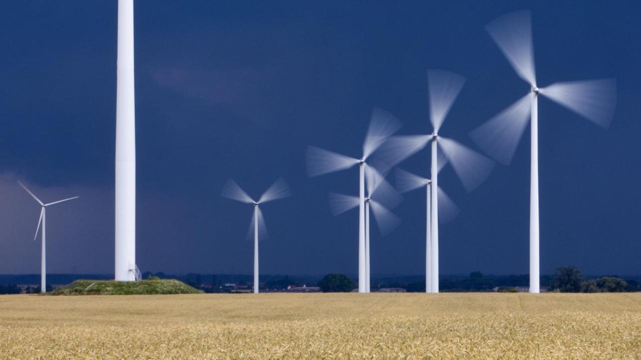 Schnell drehen sich Windenergieanlagen vor dunklen Gewitterwolken unweit dem brandenburgischen Jacobsdorf (Oder-Spree), aufgenommen am 01.07.2009.