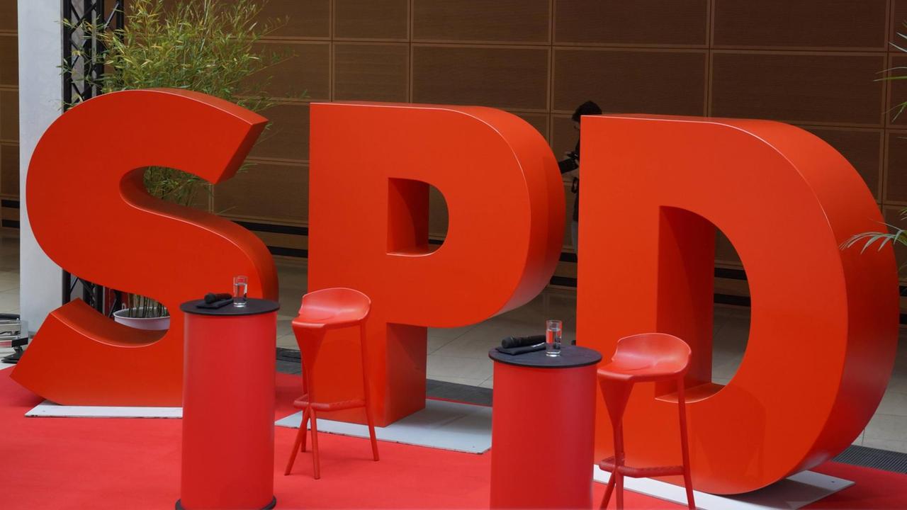 Die Buchstaben S,P und D sind in rot groß hinter zwei Stühlen aufgestellt.