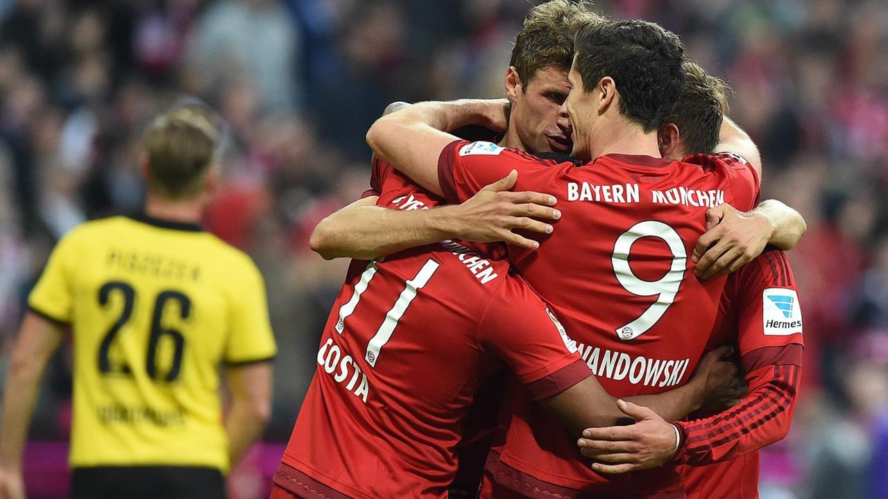 Die vier Bayern-Spieler umarmen sich. Im Hintergrund sieht man unscharf einen enttäuschten Dortmund-Spieler. Die vier Bayern-Spieler umarmen sich. Im Hintergrund sieht man unscharf einen enttäuschten Dortmund-Spieler.