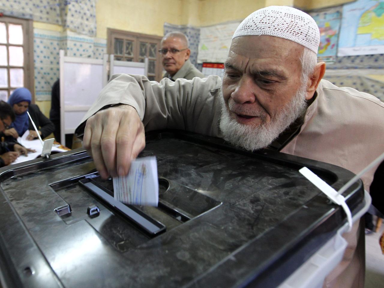 Ein älterer Mann wirft seinen Wahlschein am ersten Tag des Volksreferendums ein.