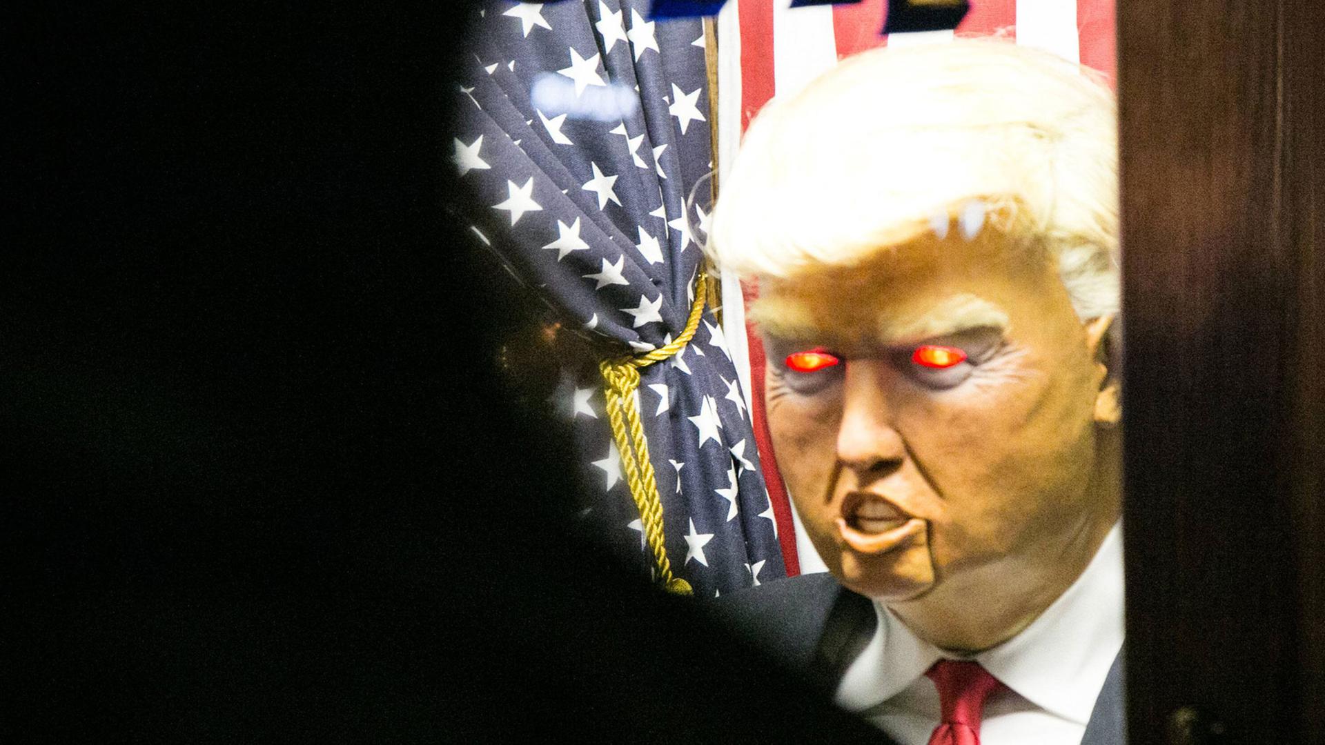 Eine Puppe von Donald Trump mit roten, teuflisch glühenden Augen
