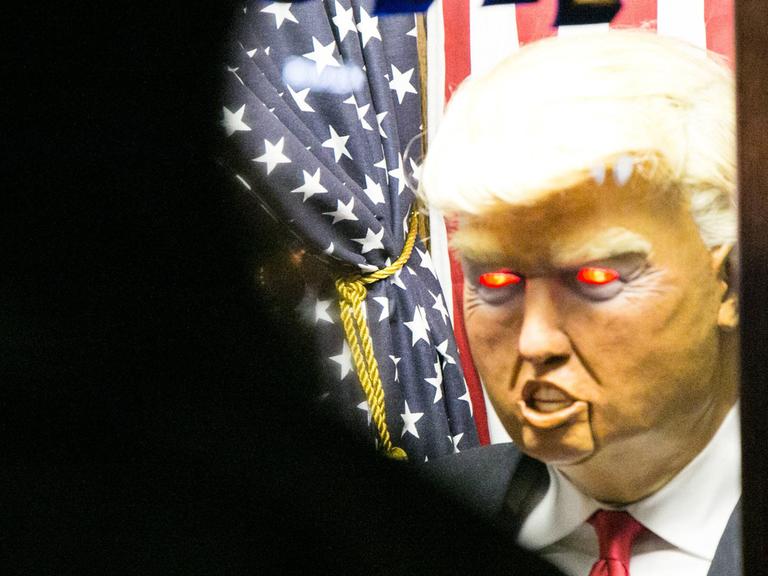 Eine Puppe von Donald Trump mit roten, teuflisch glühenden Augen