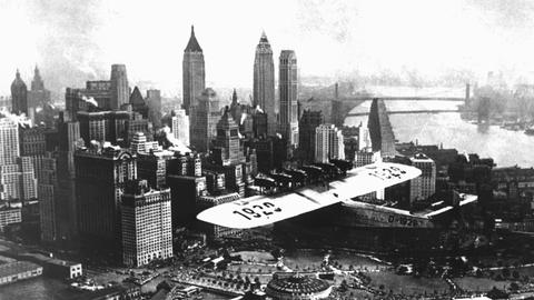 Die "Do X" beim Landeanflug über New York. Nach dem Start vom Bodensee am 5. November 1930 und nach mehreren Zwischenlandungen und unvorhergesehenen Unterbrechungen landete das Flugschiff nach seinem ersten großen Flug am 27. August 1931 in New York. Das berühmteste von den Dornier-Werken erbaute Flugboot der Vorkriegszeit war die "DO X". Am 12. Juli 1929 hob das riesige Flugschiff am Bodensee zu seinem Erstflug ab. Es war mit 12 Motoren ausgerüstet, erreichte eine Gipfelhöhe von 1250 Metern und eine Geschwindigkeit von ca. 195 Stundenkilometern. Die Überquerung des Atlantiks 1931 war der Anfang des heute selbstverständlichen Flugverkehrs über Ozeane und Kontinente.
