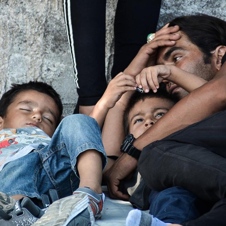 Flüchtlinge auf der griechischen Insel Lesbos: Ein Vater beobachtet seine Kinder, die auf der Straße schlafen.