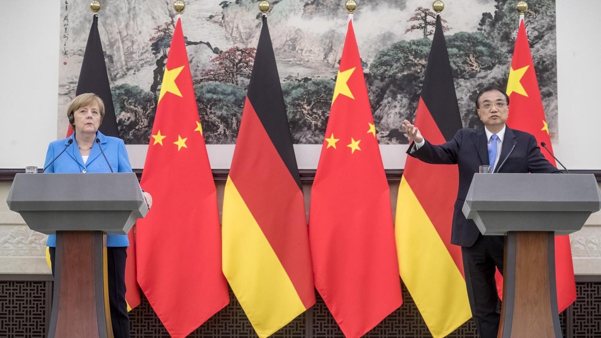 24.05.2018, Peking, China: Bundeskanzlerin Angela Merkel (CDU) steht bei einer Pressekonferenz in der Großen Halle des Volkes neben dem chinesischen Ministerpräsidenten Li Keqiang.