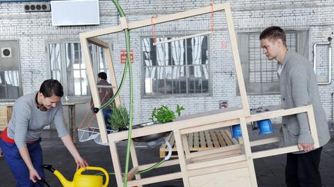 Die polnischen Designer Anna Rosike und Maciej Chmara schieben am Dienstag (05.06.2012) in Berlin auf der Designmesse DMY ihre mobile Küche durch die Halle.