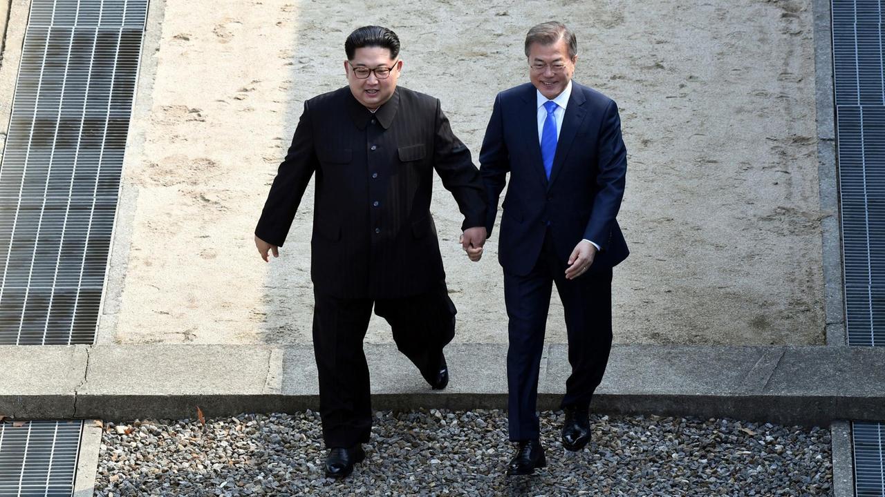Kim Jong Un (l.) und Moon Jae-in beim Überqueren der Demarkationslinie