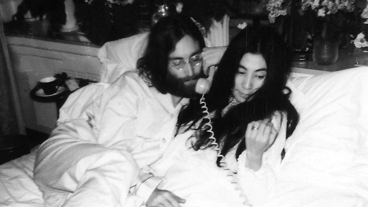 John Lennon und Yoko Ono liegen in einem Hotelbett und telefonieren