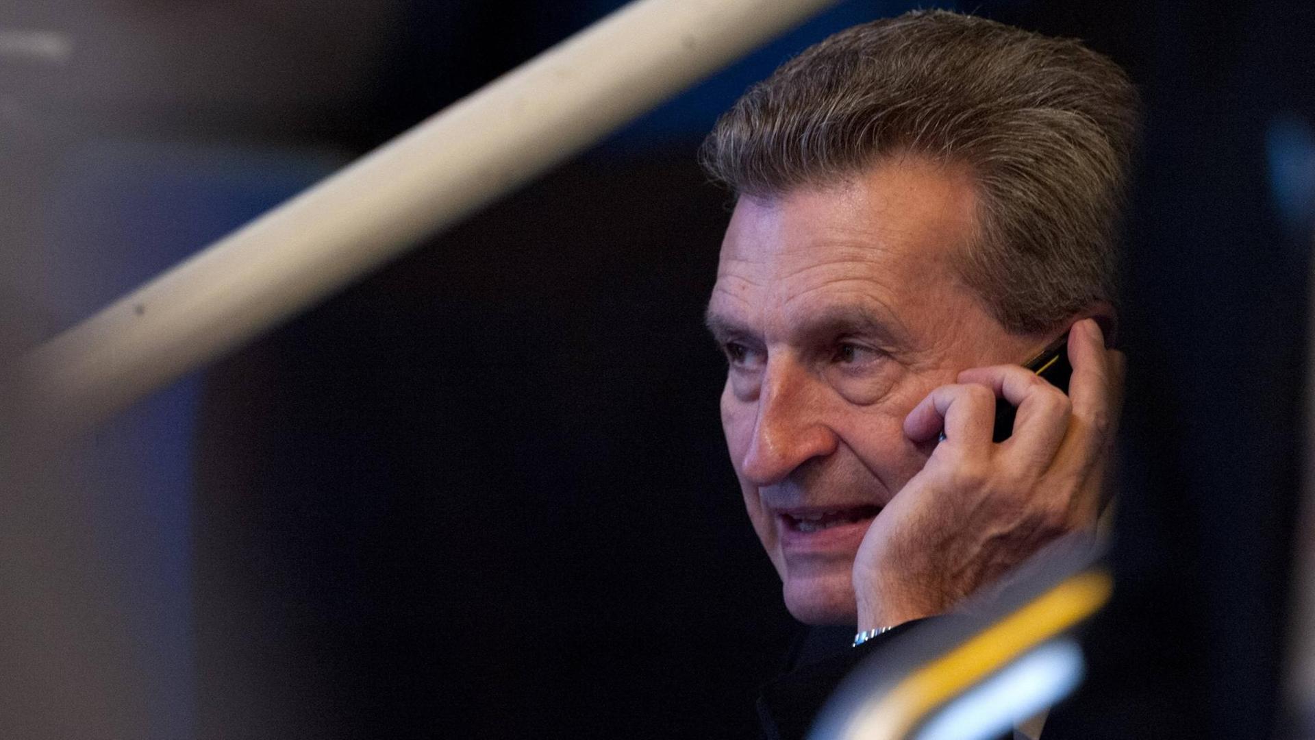 EU-Haushaltskommissar Günther Oettinger telefoniert mit einem Handy.