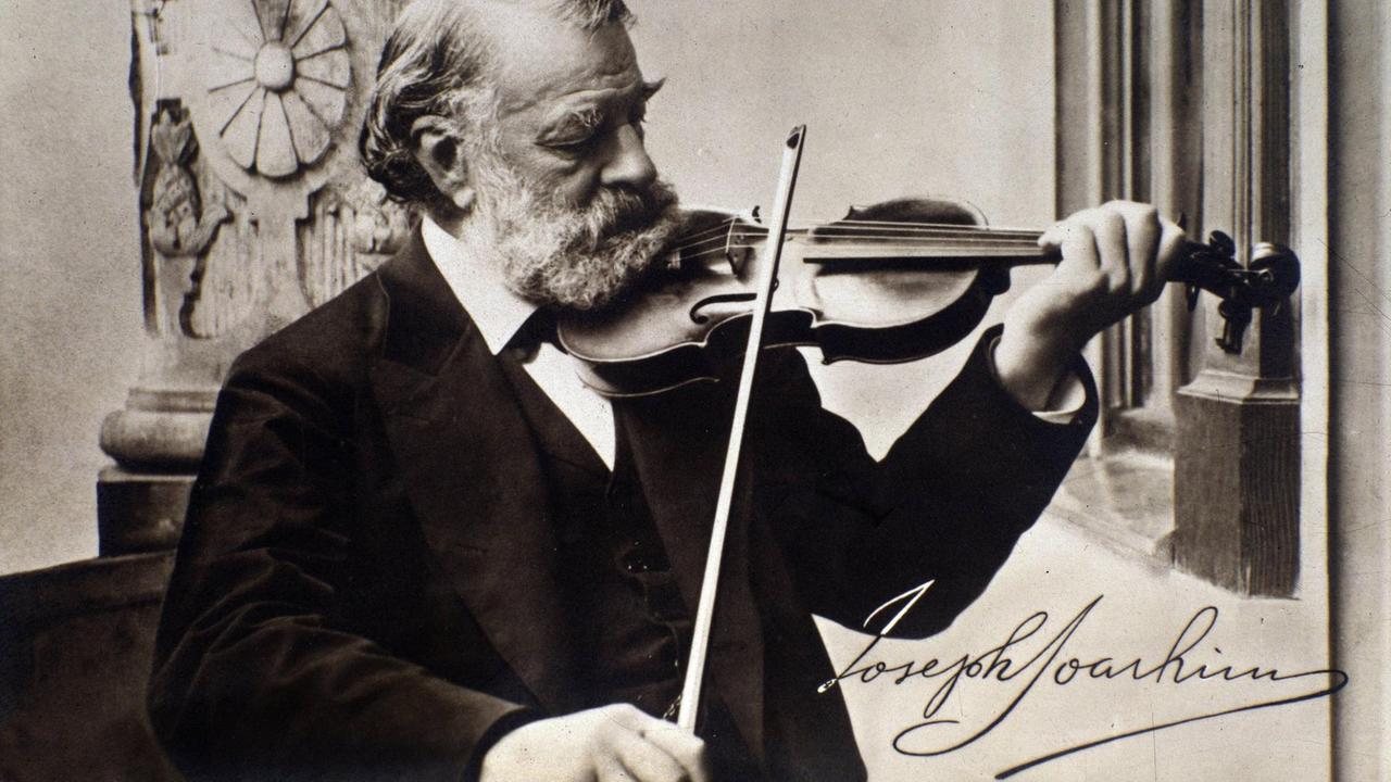 Fotographie mit eigenhändiger Unterschrift des Jahrhundertgeigers, der mit großem Bart seine Geige spielt.